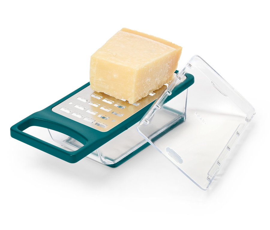 Un morceau de fromage est posé sur une râpe à fromage verte avec récipient.