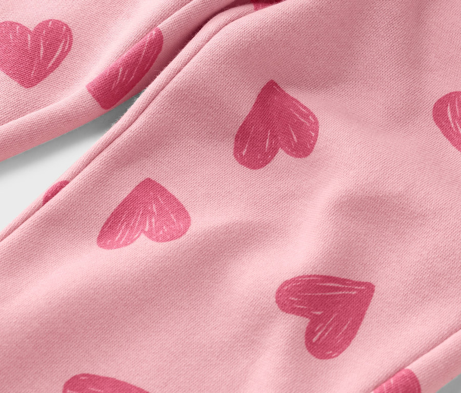Gros plan d'un pantalon rose clair avec des imprimés de cœurs roses.