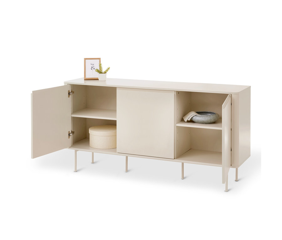 Un buffet beige clair avec quatre pieds et trois compartiments. Sur le dessus, il y a un petit cadre photo et une plante en pot. La porte gauche est ouverte, révélant deux étagères avec une boîte ronde sur celle du bas. Le compartiment central a une porte coulissante fermée. La porte droite est ouverte, montrant deux étagères avec un bol gris et un tissu sur celle du haut.