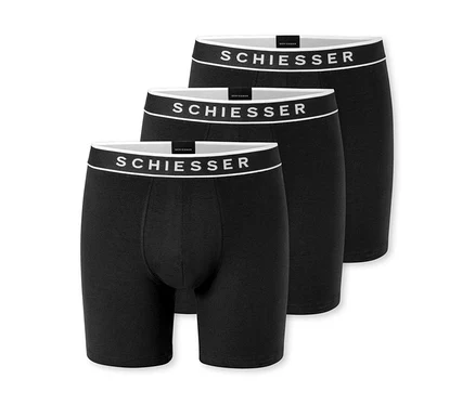 Trois boxers noirs, légèrement décalés les uns derrière les autres, avec une ceinture blanche et le logo « SCHIESSER ».