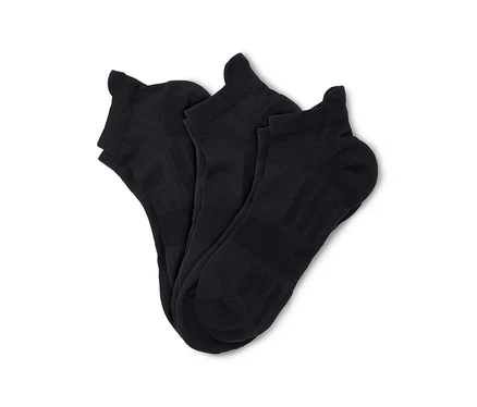 Trois chaussettes de cheville noires sont soigneusement pliées et disposées sur un fond blanc.