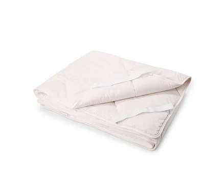 Un protège-matelas matelassé beige clair plié avec des sangles élastiques.