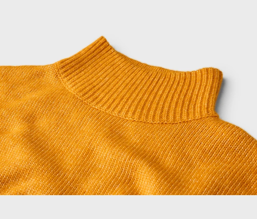 Pull en maille jaune avec col montant côtelé et texture légèrement chinée.
