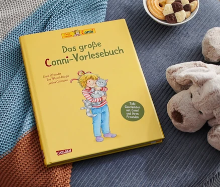 Sur un tabouret bleu sont posés le livre jaune «
Das große Conni-Vorlesebuch
», un chien en peluche, un bol de biscuits et une couverture tricotée.
