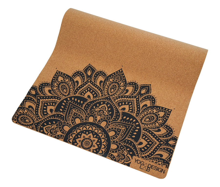 Tapis de yoga en liège déroulé avec motif floral noir.