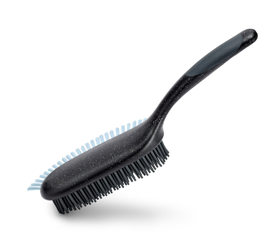 Brosse pour surfaces rembourrées et textiles avec manche noir et poils gris.