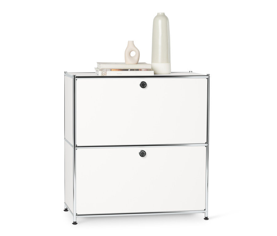 Petit buffet en métal « CN3 » blanc à abattants avec deux vases dessus.