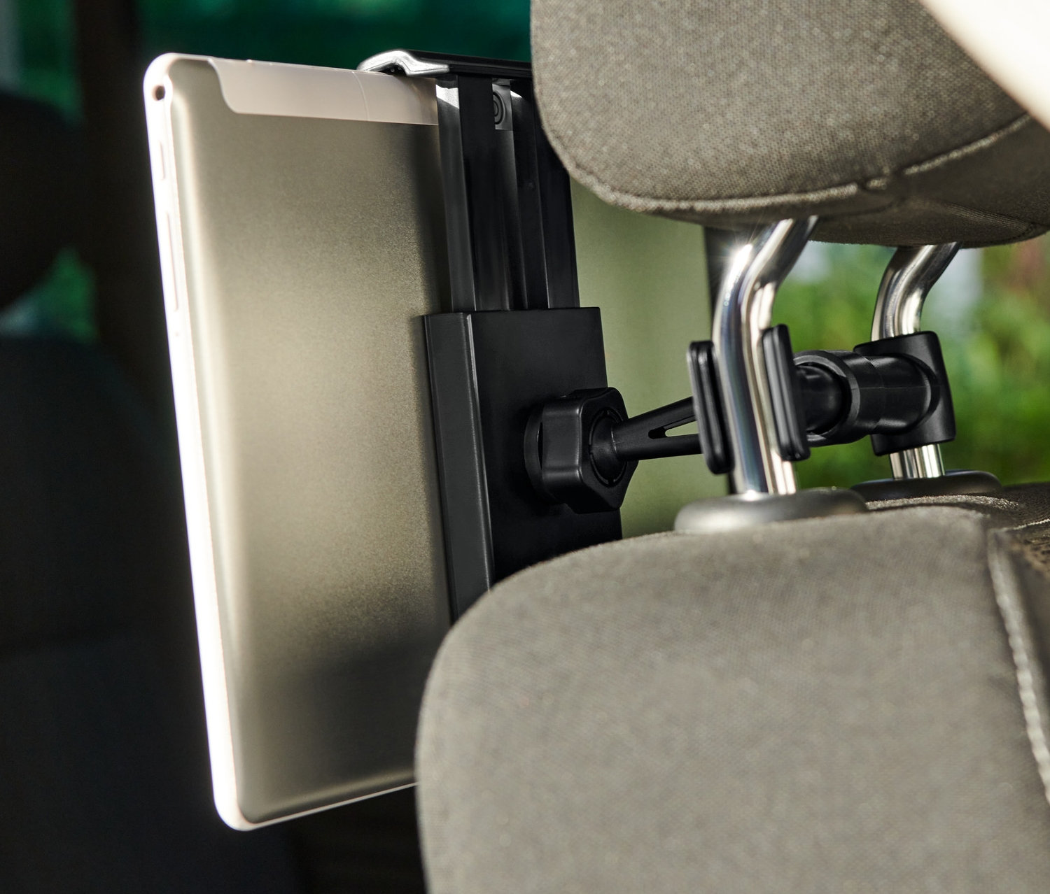 Tablette fixée à un support de tablette de voiture, lui-même fixé à l'appuie-tête du siège.