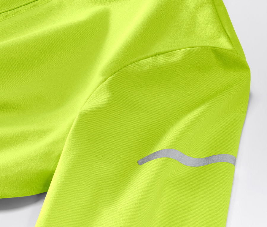 Gros plan sur un t-shirt technique thermique vert fluo à manches longues avec un détail réfléchissant.