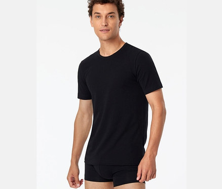 Un homme porte un t-shirt noir SCHIESSER en coton bio d'un lot de 2.