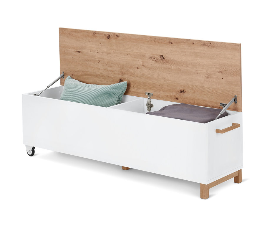Banc de lit avec fonction coffre ouvert, à l'intérieur un coussin vert et une couverture grise.
