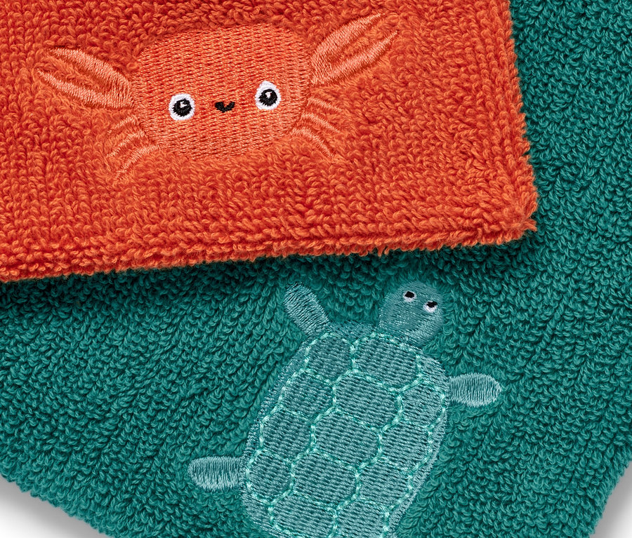 Deux gants de toilette : un orange avec un crabe et un turquoise avec une tortue.