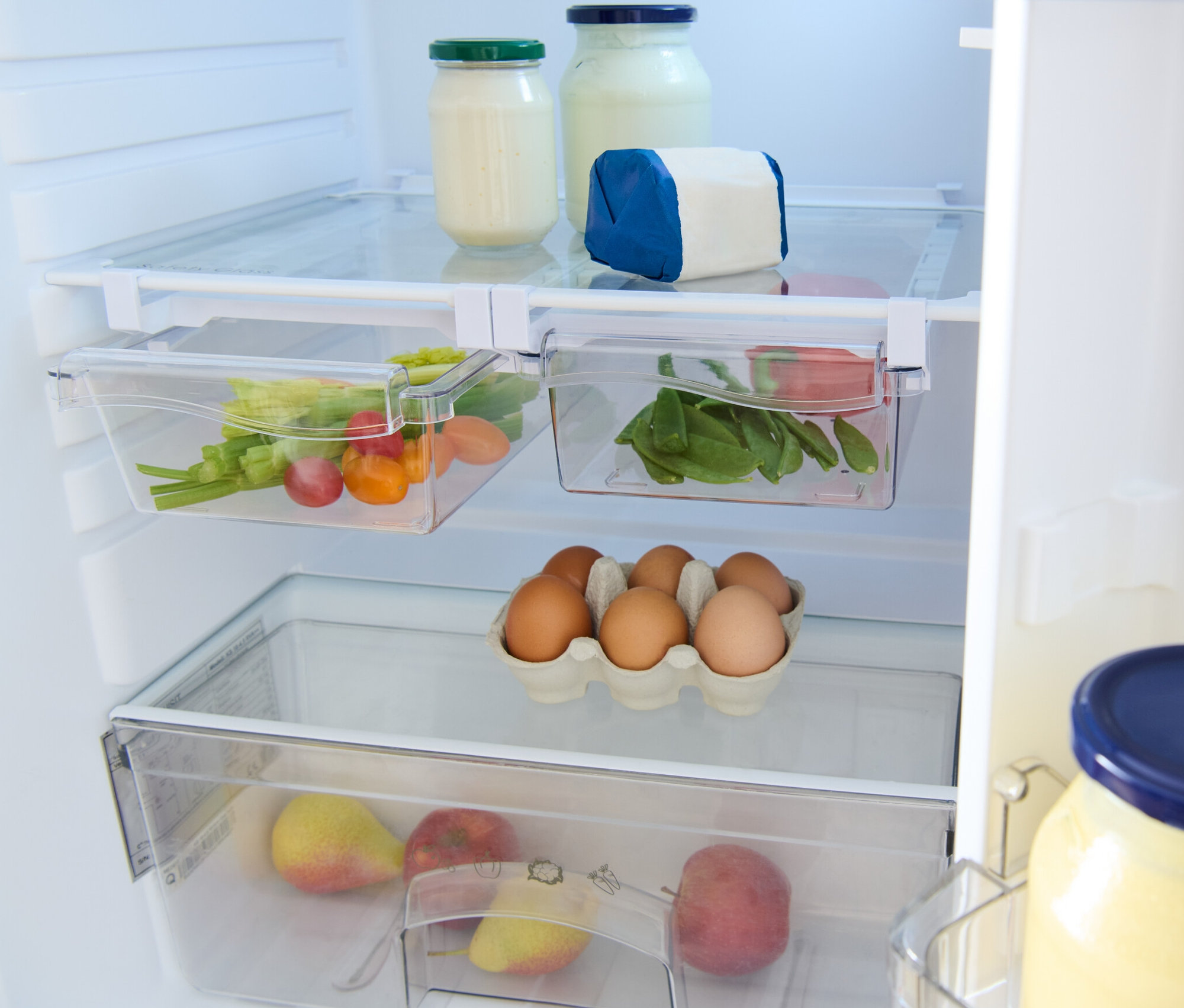 À l'intérieur du réfrigérateur, il y a 2 compartiments de réfrigérateur extensibles, des verres, des œufs et des fruits.