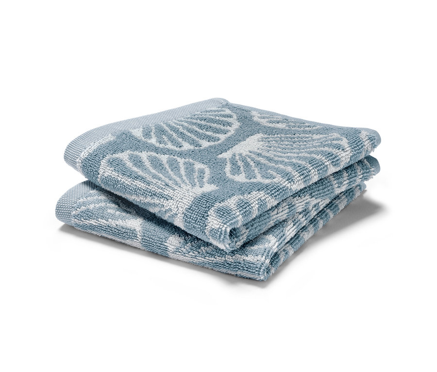 Deux 2 lavettes bleues pliées avec un motif de coquillages.