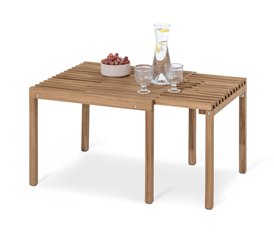 Table basse extensible « Tinus » en bois avec deux verres, une carafe d'eau et un bol de fruits.