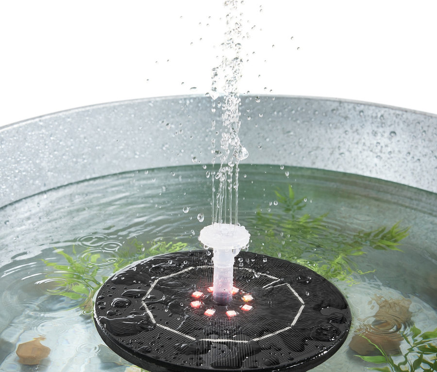 Fontaine flottante à énergie solaire avec éclairage pulvérisant de l'eau dans un seau métallique.