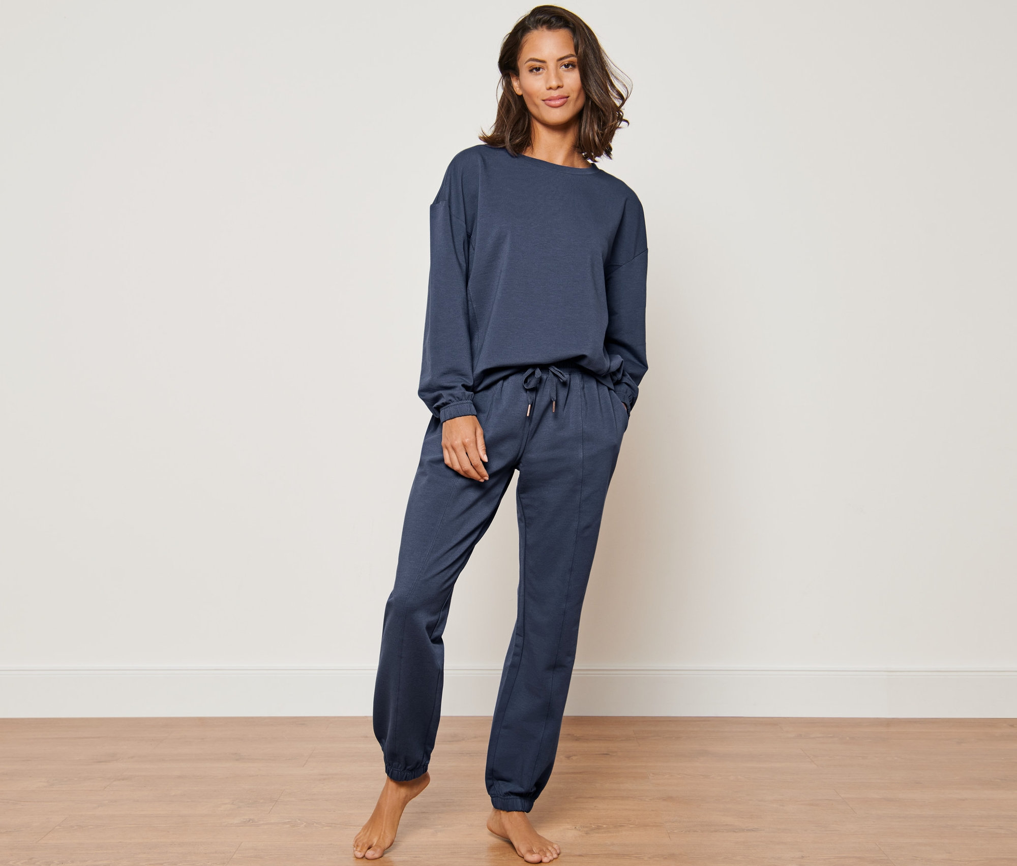 Femme posant dans un survêtement d’intérieur bleu marine.