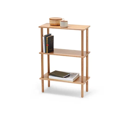 Étagère à trois niveaux avec deux boîtes décoratives et des livres.