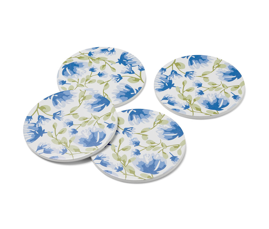 Quatre sous-verres avec un motif floral bleu.