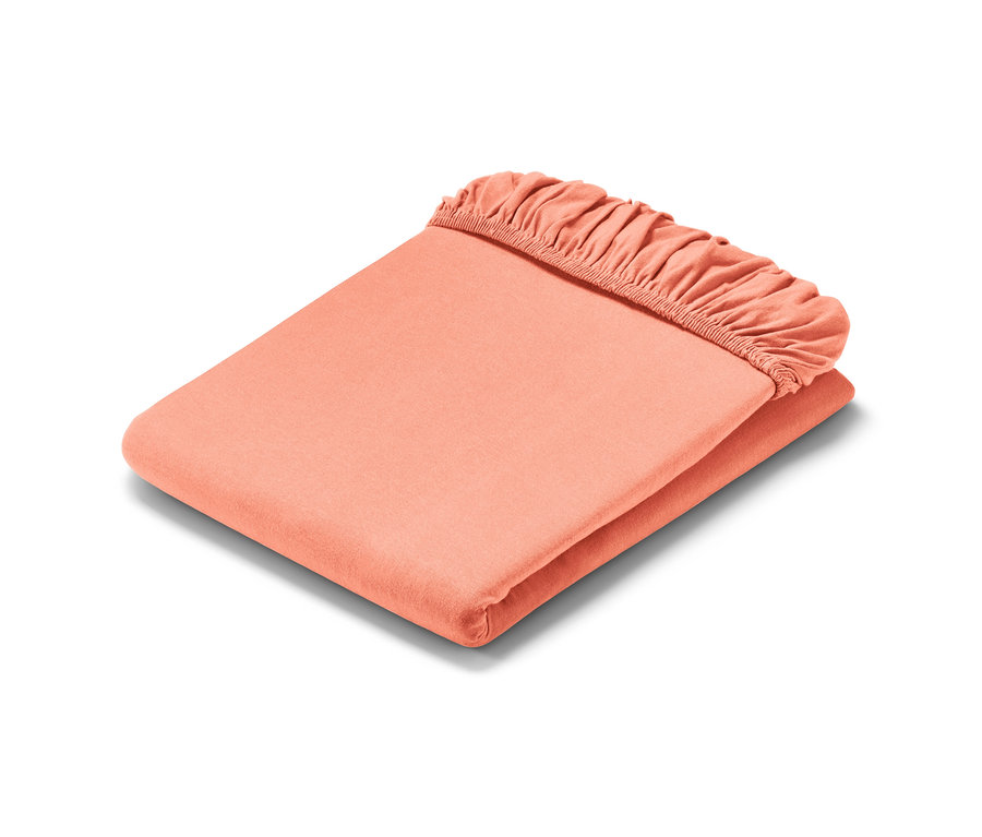 Un drap-housse en jersey corail plié.