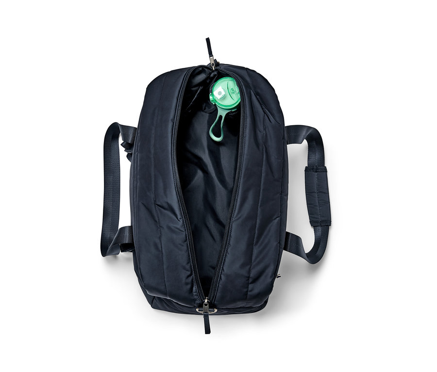 Sac de sport noir ouvert avec une bouteille d'eau verte à l'intérieur.