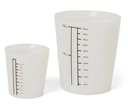 Deux tasses à mesurer blanches de différentes tailles avec des marques noires.