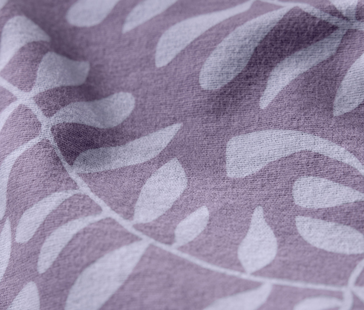 Gros plan d'un tissu violet avec un motif de feuilles blanches.