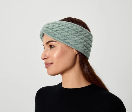 Portrait d'une femme aux cheveux bruns portant un bandeau tricoté vert clair.