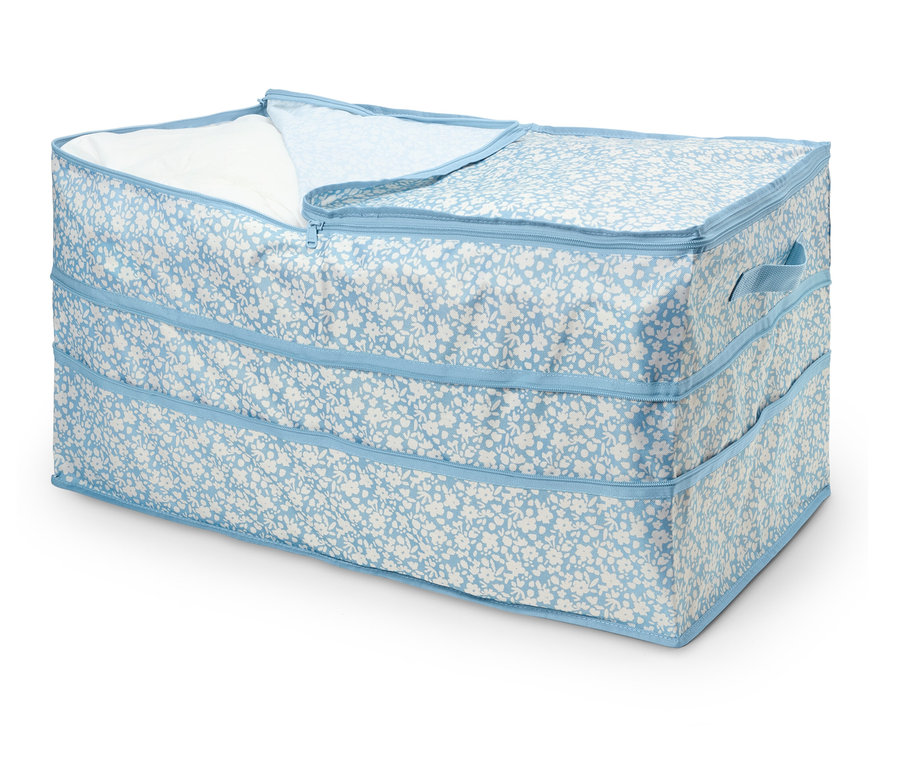 Une boîte de rangement à fleurs bleues avec une fermeture éclair, partiellement ouverte, révélant un tissu blanc à l'intérieur.