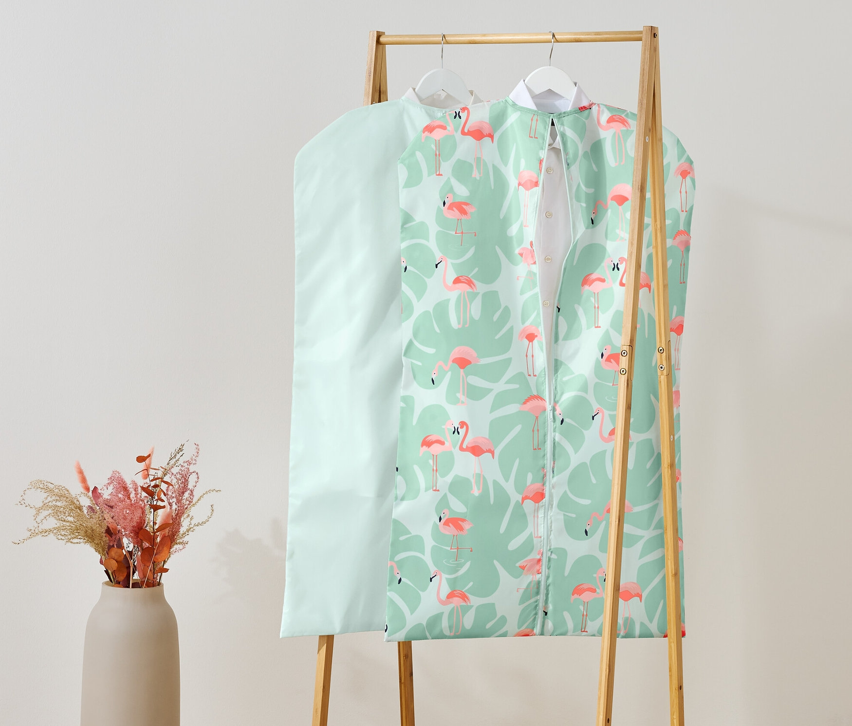 Deux housses de protection pour vêtements suspendues à un portant à vêtements.