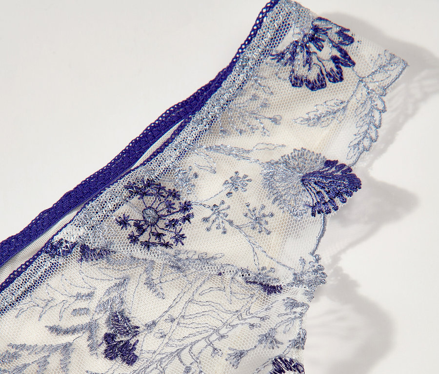 Détail du tanga blanc Passionata « Chloe » avec broderie florale bleue.