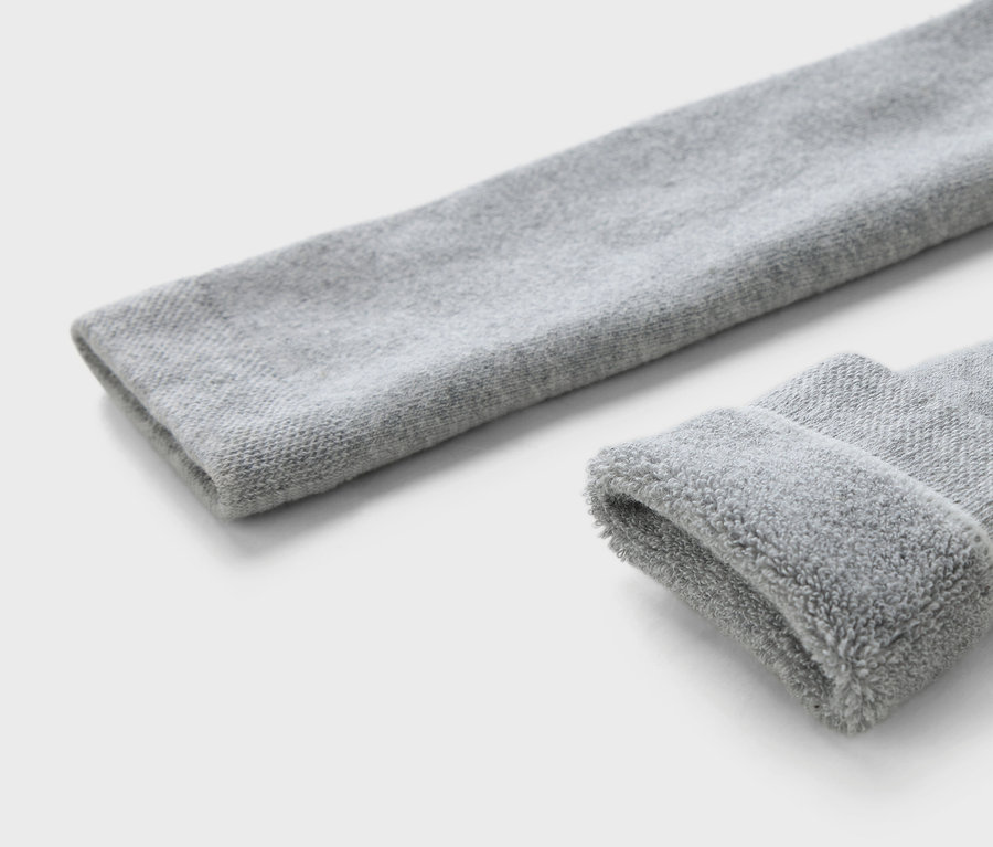 Gros plan sur trois leggings thermiques pour enfants en marron, gris et bleu.