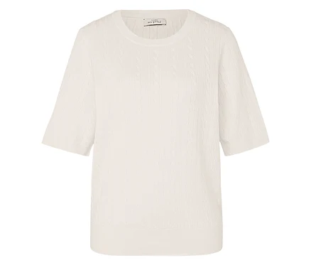 Un haut en tricot couleur crème avec un motif de torsades et des manches courtes.