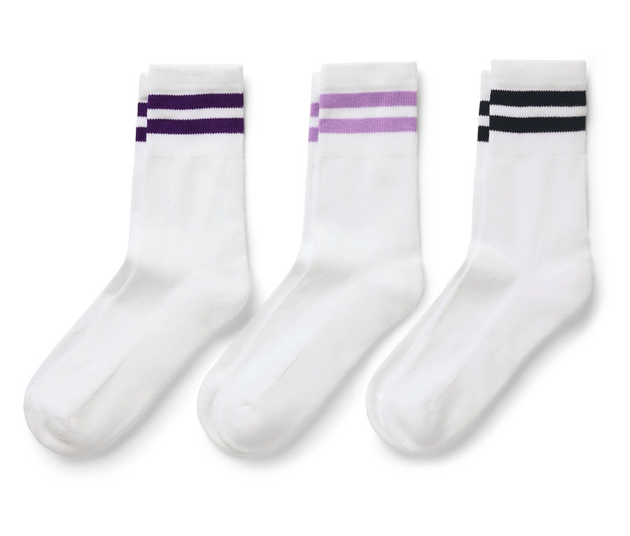 Trois chaussettes blanches avec des rayures colorées sur le dessus.