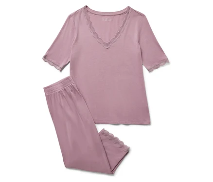 Un pyjama violet avec de la dentelle sur un fond blanc.