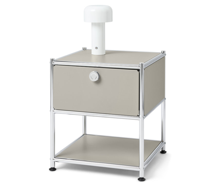 Table de chevet avec tiroir et une lampe blanche dessus.