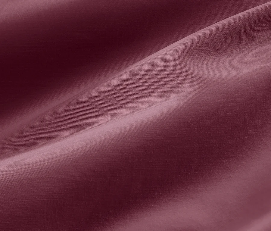 Gros plan sur la texture d'une parure de lit en satin de coton baie en grande taille.