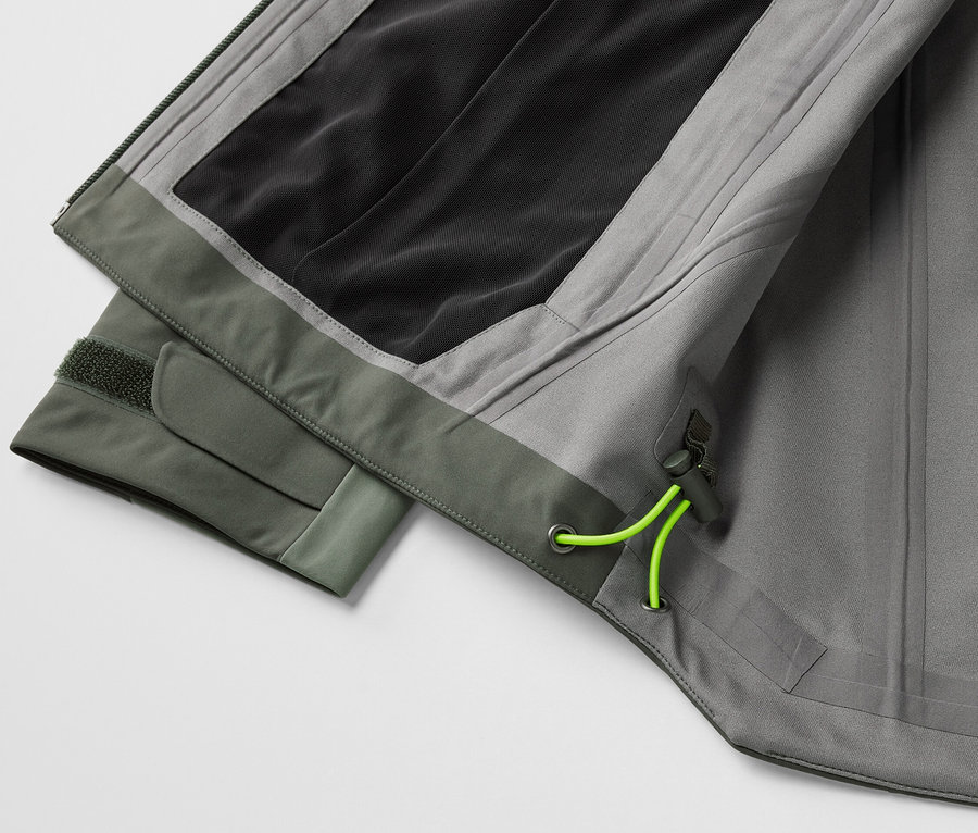 Détail d'une veste outdoor 3 couches grise avec des éléments verts.