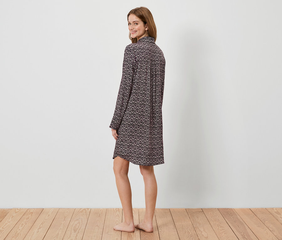 Femme regardant par-dessus son épaule en chemise de nuit à manches longues à motifs.