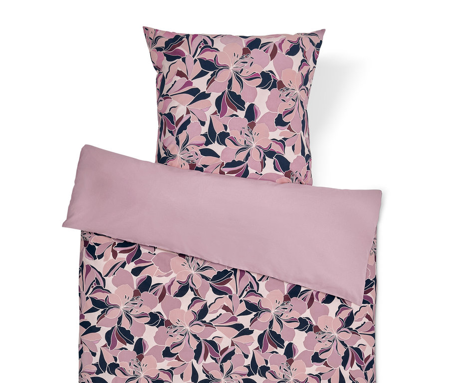 Ensemble de literie avec motif floral et oreiller violet clair.