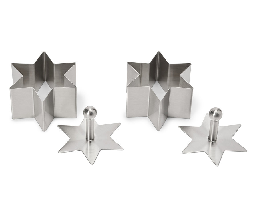 Deux emporte-pièces en forme d'étoile et deux tampons à biscuits en forme d'étoile en acier inoxydable sur fond blanc.
