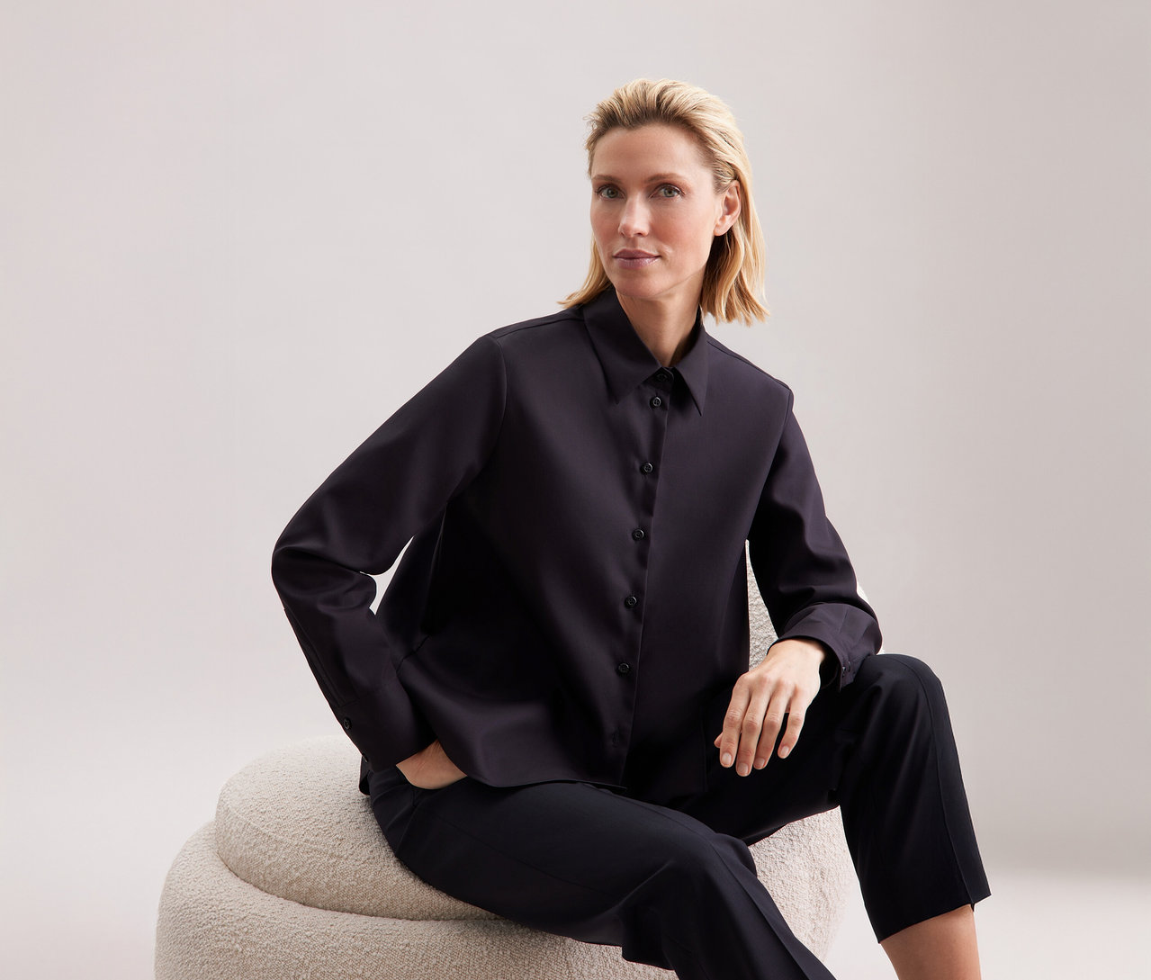 Femme assise portant une chemise Seidensticker.