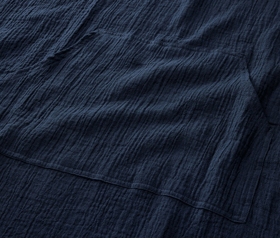 Gros plan sur un poncho de rechange en mousseline bleu marine avec poche.