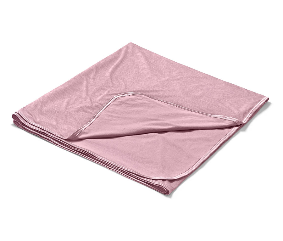 Une couverture rafraîchissante rose est pliée sur un fond blanc.