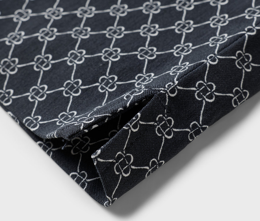 Gros plan d'un morceau de tissu plié avec un motif floral blanc sur un fond bleu marine.