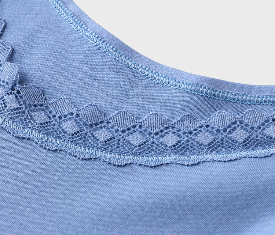Gros plan d'un haut bleu clair avec une bordure en dentelle à l'encolure.