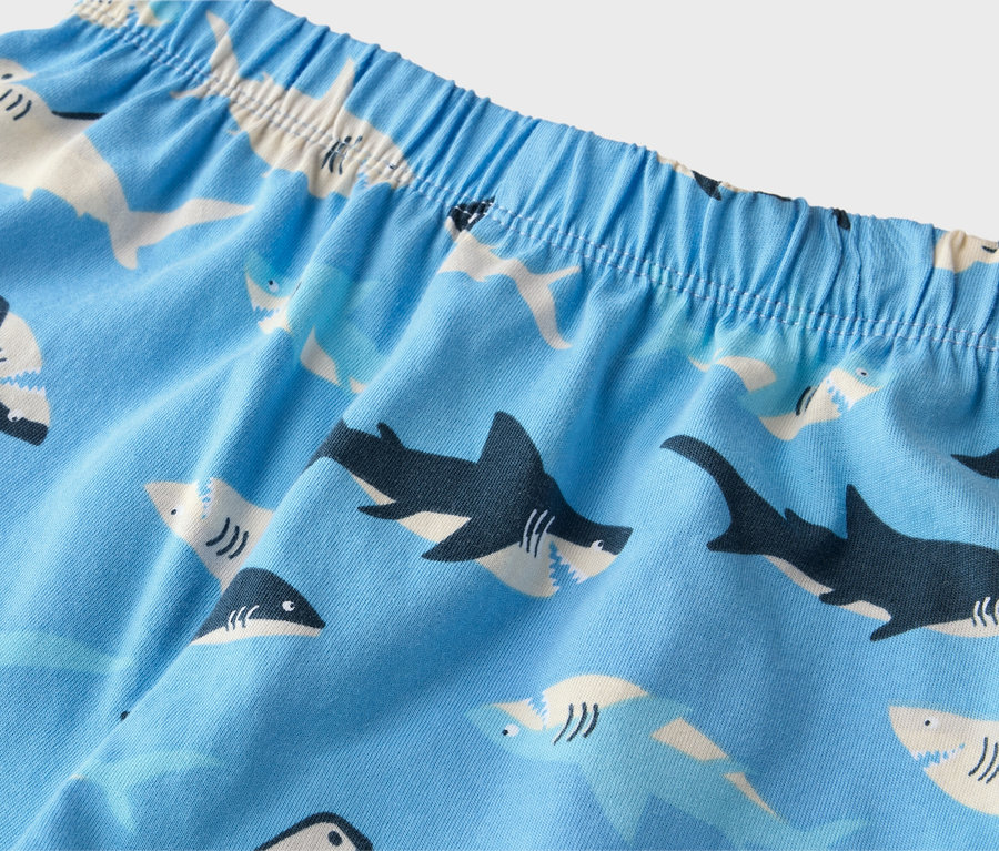 Gros plan d'un vêtement bleu clair avec une taille élastique et un motif de requins.
