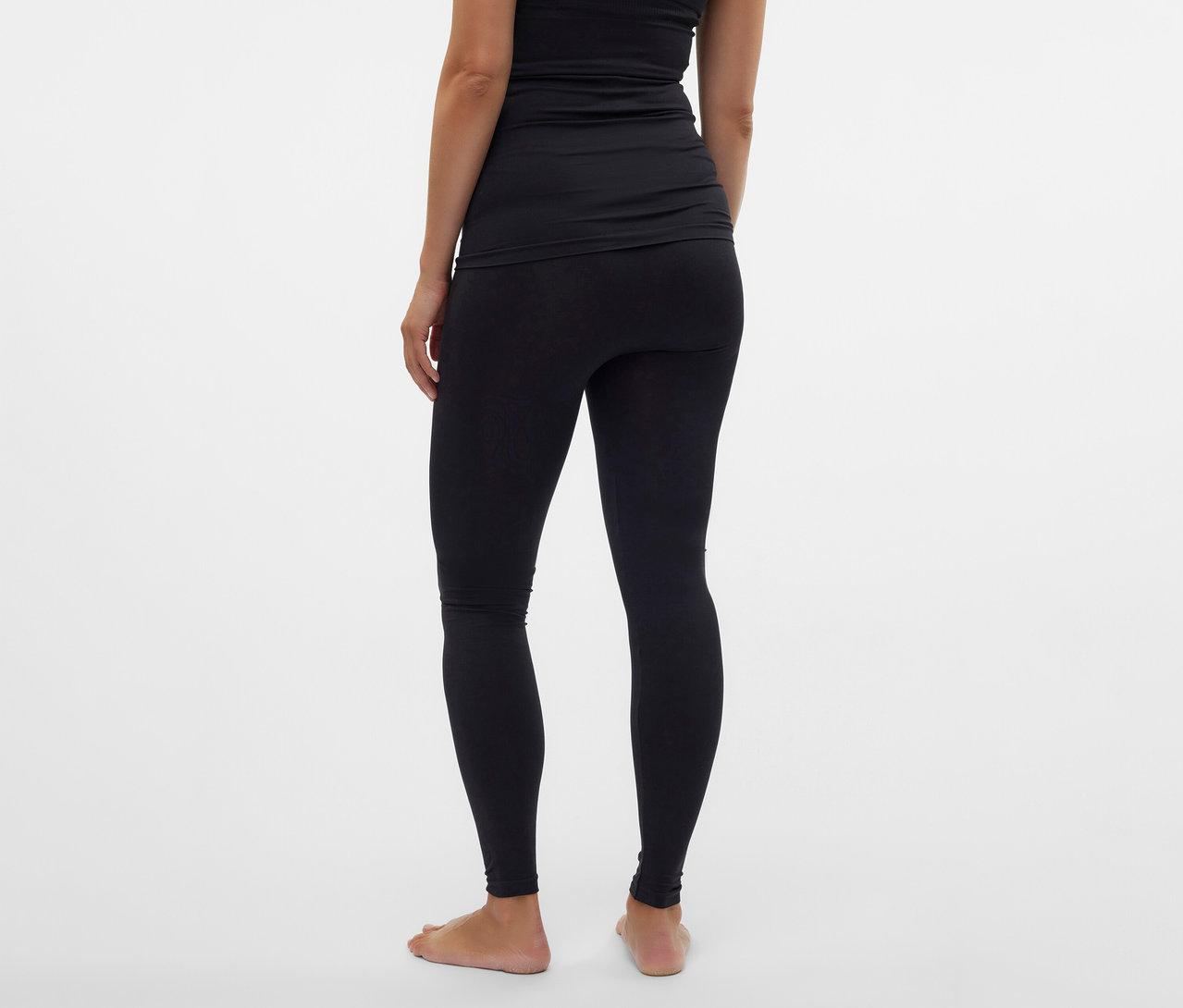 Vue arrière d'une femme portant un legging skinny MAMALICIOUS «
MLTIA JEANNE » noir et un haut noir sur fond blanc.