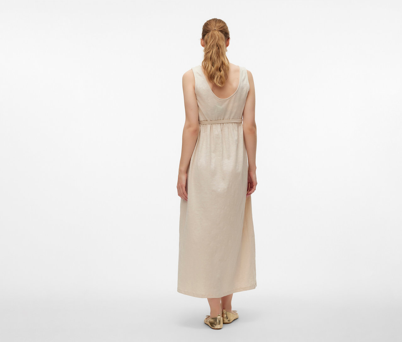 Vue de dos d'une femme portant une robe de grossesse MAMALICIOUS «
MLEVI LIA » et des chaussures dorées sur fond blanc.