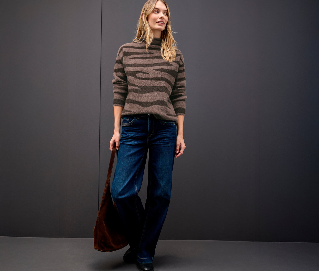 Femme portant un pull en jacquard Street One, un jean et un sac à main.